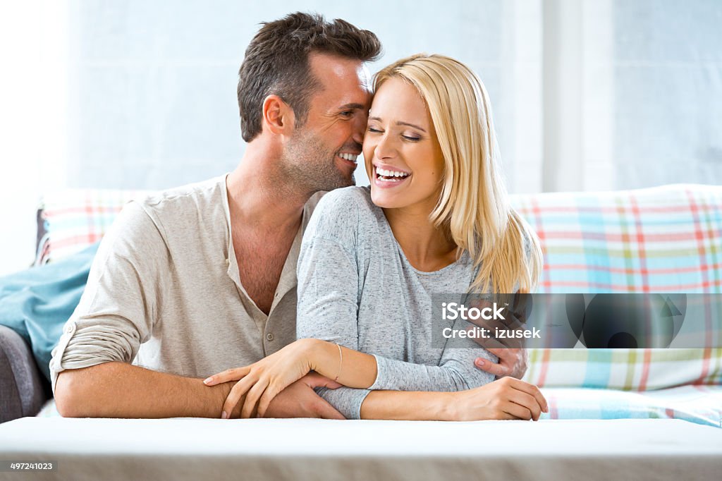 Happy couple at home Indoors portrait of happy couple embracing at home. Blond Hair Stock Photo