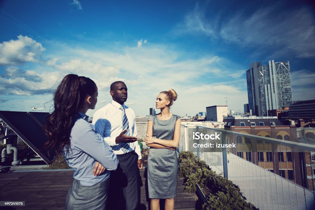 Business people Three business people talking on the rooftop with the view over the London City. Adult Stock Photo
