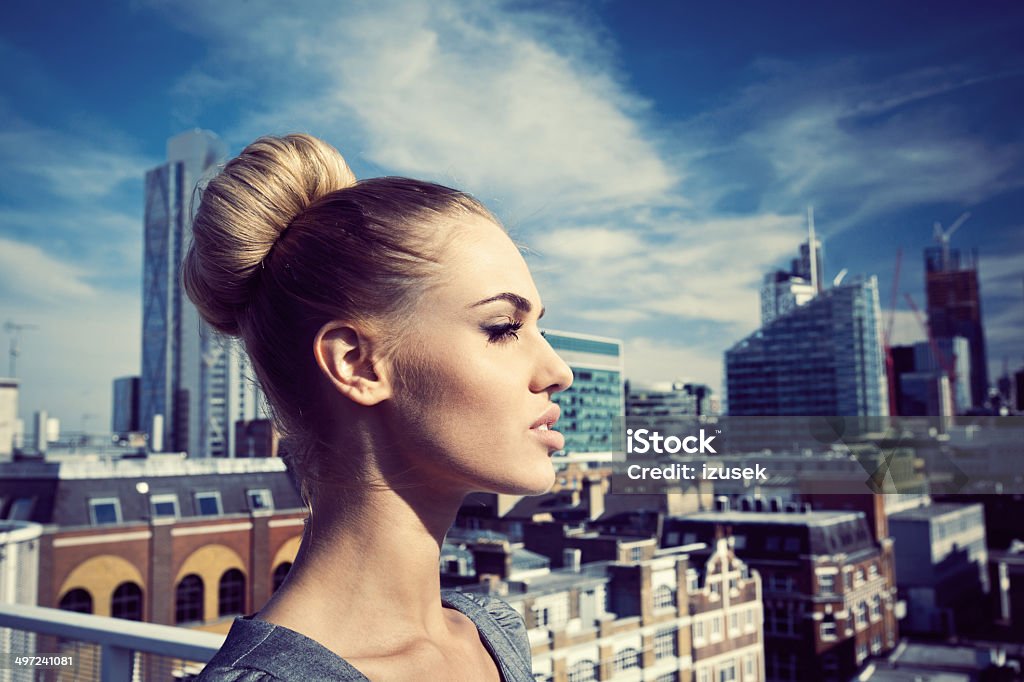 Successful businesswoman Side view of confident businesswoman standing on the rooftop with the view over the London City. Achievement Stock Photo
