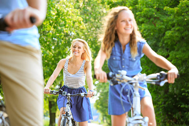 Happy family cycling Parents and daughter cycling on a bicycles in a park. Focus on the beautiful mother. teenager couple child blond hair stock pictures, royalty-free photos & images