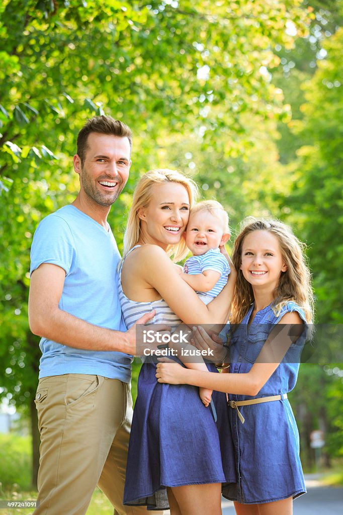 Happy family in a park Outdoor portrait of happy parents with their children.  Baby - Human Age Stock Photo