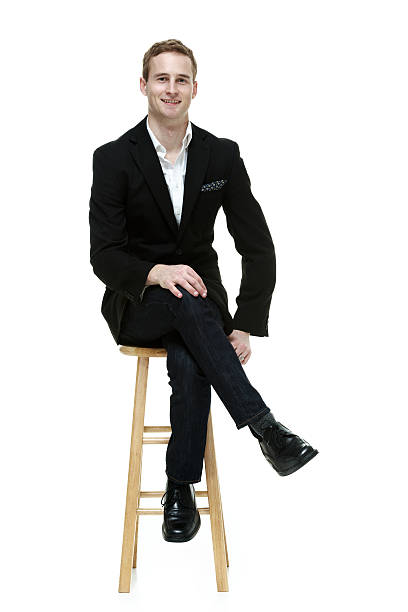Front view of happy businessman sitting on stool Front view of happy businessman sitting on stoolhttp://www.twodozendesign.info/i/1.png legs crossed at knee stock pictures, royalty-free photos & images