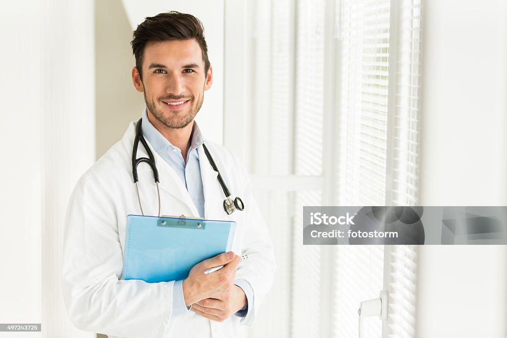 Male doctor taking notes Male doctor taking notes. Adult Stock Photo