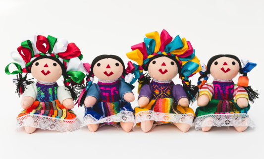 Four Mexican dolls seated in line.
