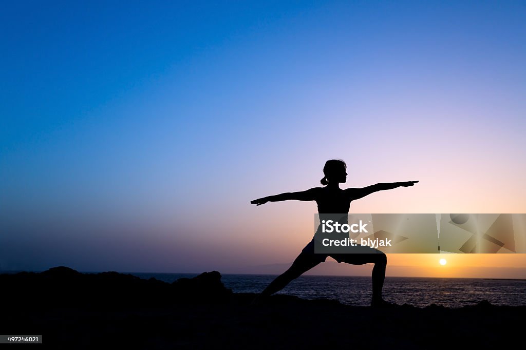 Woman training yoga pose silhouette Young woman doing yoga pose warrior one, sunset silhouette in mountains. Sport and exercising in beautiful nature outdoors Yoga Stock Photo