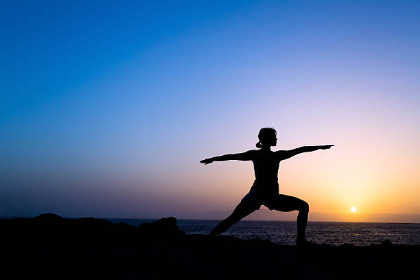 Woman training yoga pose silhouette stock photo