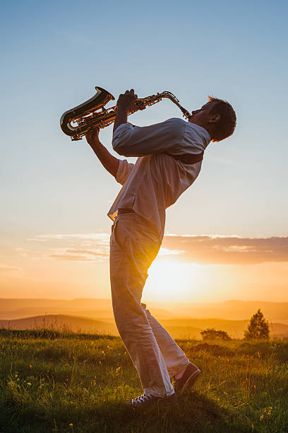 istock one young Saxophonist playing outdoor at sunset 497246267