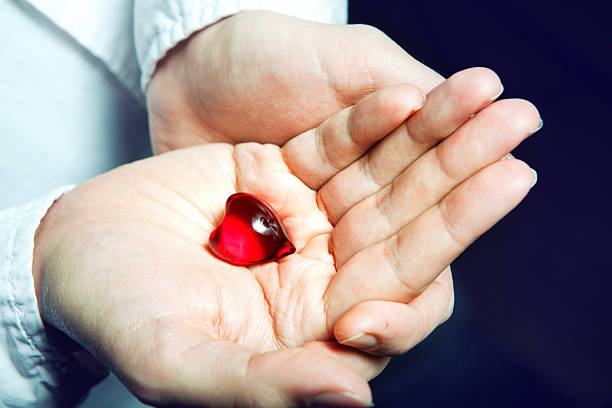 istock man holding a red heart in hands, 497246647