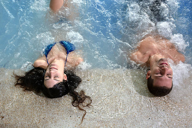 couple in hot tub enjoying a hydrotherapy session stock photo