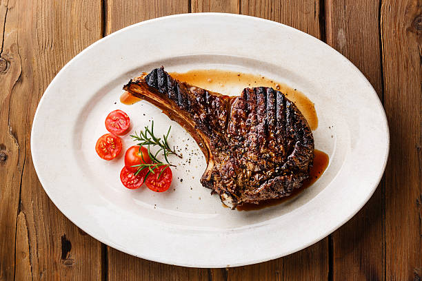 istock Grilled Ribeye Steak on bone and tomatoes 497248956