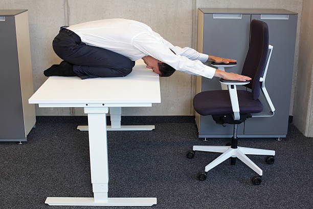 istock yoga in office. business man exercising at workplace 497250376