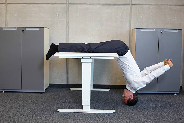 yoga im büro business-mann, der ausübung am arbeitsplatz - ergonomische tastatur stock-fotos und bilder