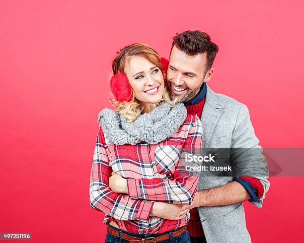 Happy Couple In Winter Outfit Against Red Background Stock Photo - Download Image Now