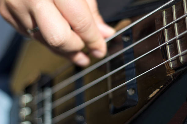 istock Closeup of electrical bass guitar strings with fingers on it 497251270