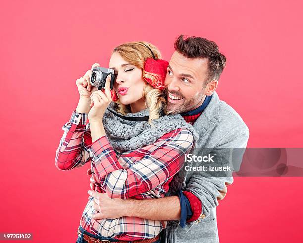 Happy Couple In Winter Outfit Against Red Background Stock Photo - Download Image Now