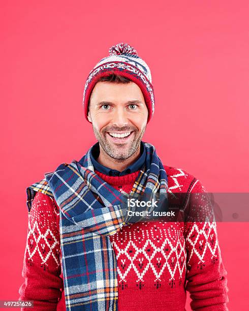 Happy Man In Winter Outfit Against Red Background Stock Photo - Download Image Now - Men, Cap - Hat, Christmas