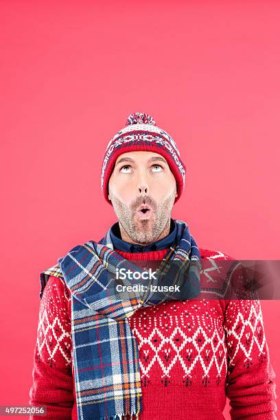 Surprised Man In Winter Outfit Against Red Background Stock Photo - Download Image Now