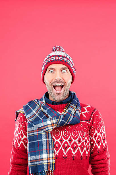 heureux homme en tenue d'hiver sur fond rouge - men sweater excitement satisfaction photos et images de collection