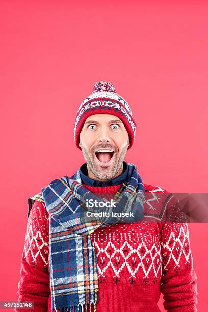 Excited Man In Winter Outfit Against Red Background Stock Photo - Download Image Now