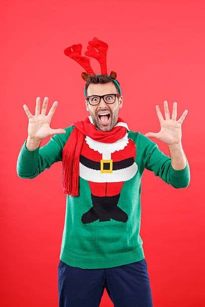 istock Shocked nerd man in funny winter outfit against red background 497252334