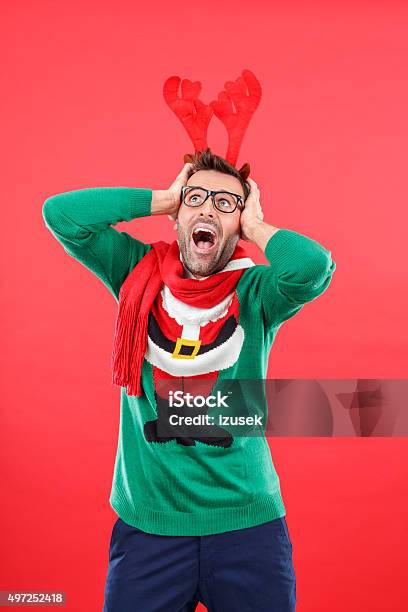 Terrified Nerd Man In Funny Winter Outfit Against Red Background Stock Photo - Download Image Now