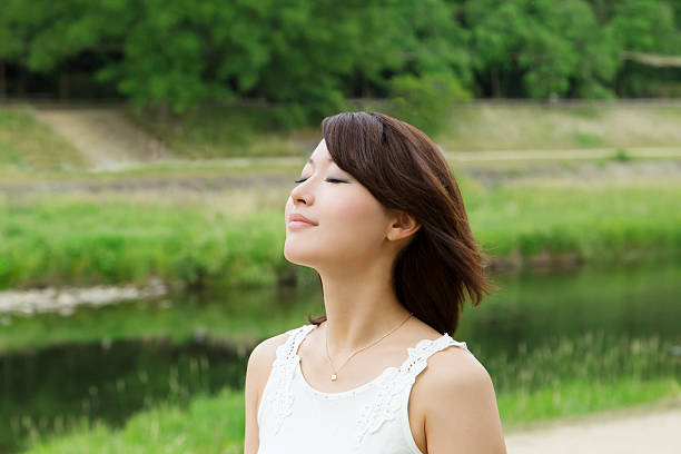 Asian girl beside river. breath and relax stock photo