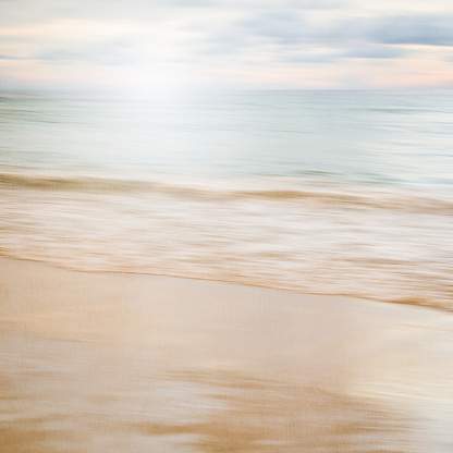 An abstract seascape with blurred panning motion with cross-processed colors on paper background