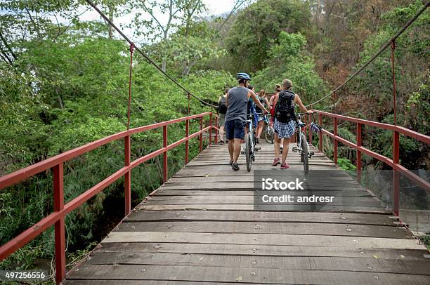 Mountain Bikers Crossing A Bridge Stock Photo - Download Image Now - 20-29 Years, 2015, 30-39 Years