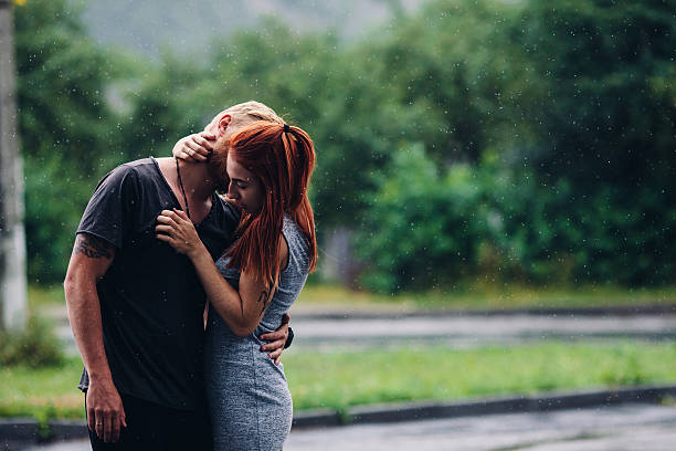 istock beautiful couple hugging in the rain 497256684