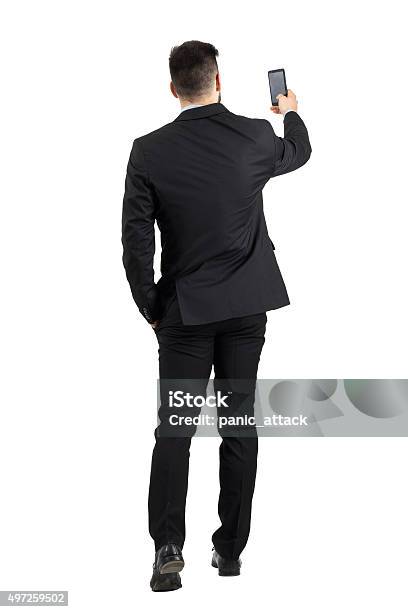 Businessman Searching For Phone Signal Rear View Or Taking Photo Stock Photo - Download Image Now