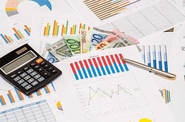 istock money, calculator, pen on financial paper graphs 497259520