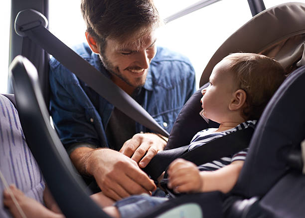 Safety first A young father strapping his baby into a car seathttp://195.154.178.81/DATA/i_collage/pi/shoots/783361.jpg buckle photos stock pictures, royalty-free photos & images
