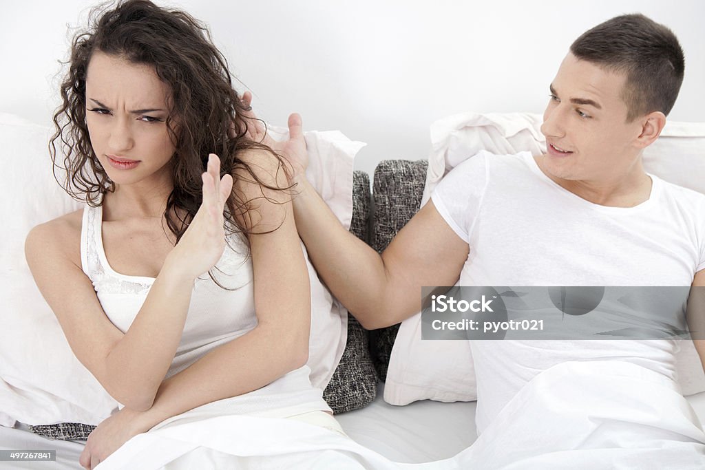 woman arguing with his hubby in their bedroom unhappy young  couple in bedroom under stress Adult Stock Photo