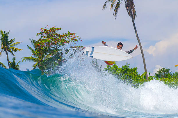 Surfer Girl in Dominican Republic taking a hit on a big wave