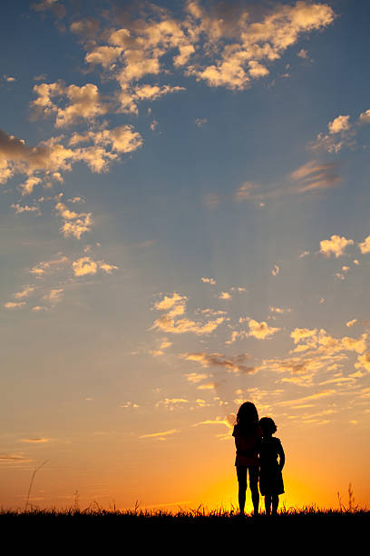 istock Silhouette of Two Caucasian Children Bonding at Sunset 497268961
