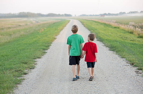 istock Two Boys Walking Down a Country Road 497269159