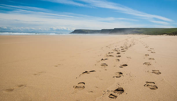 Footprints of hiking boots on a remote beach