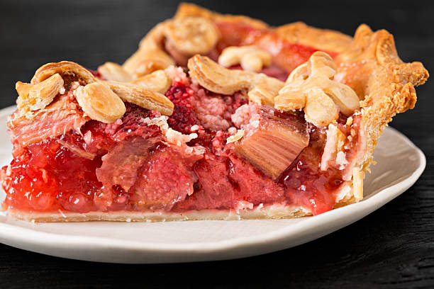 Slice Of Strawberry Rhubarb Pie An extreme close up shot of a slice of freshly baked strawberry rhubarb pie. rhubarb photos stock pictures, royalty-free photos & images