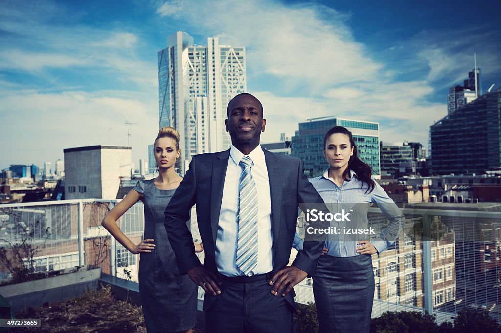 Business Superheroes Three business people standing on the rooftop with the view over the London City. Superhero Stock Photo