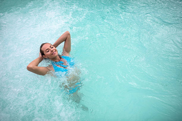 istock Beautiful woman in a swimming pool 497276504