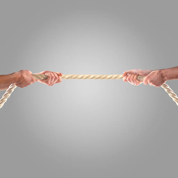 istock Hands of people pulling the rope on a gray background 497276856