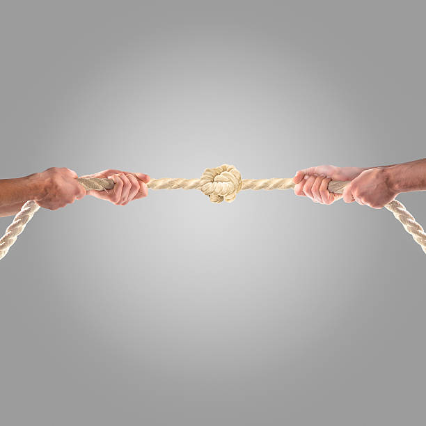 istock Hands of people pulling the rope on a gray background. 497277376