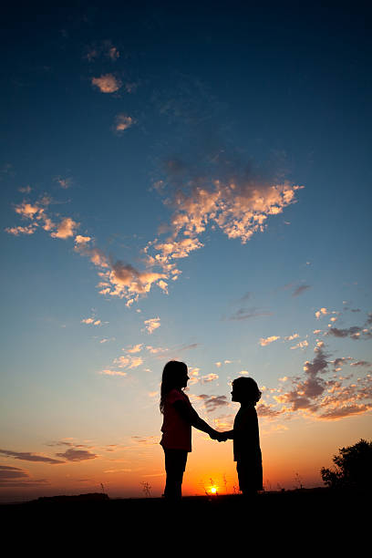 istock Silhouette of Two Children Holding Hands 497279819