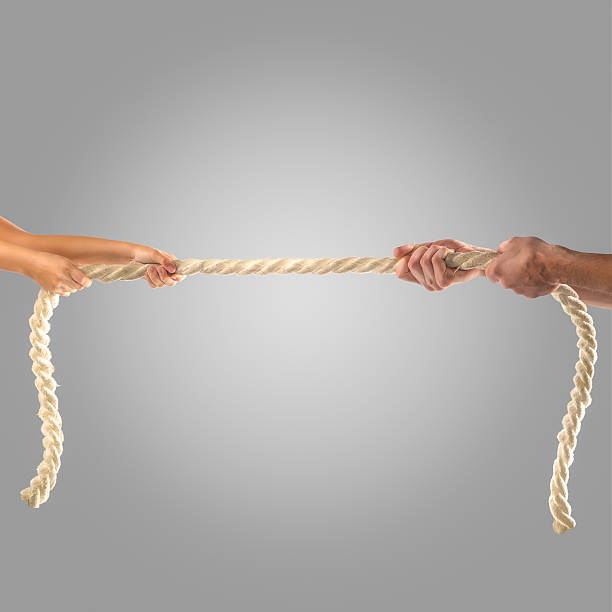 istock Hands of people pulling the rope on a gray background. 497280586