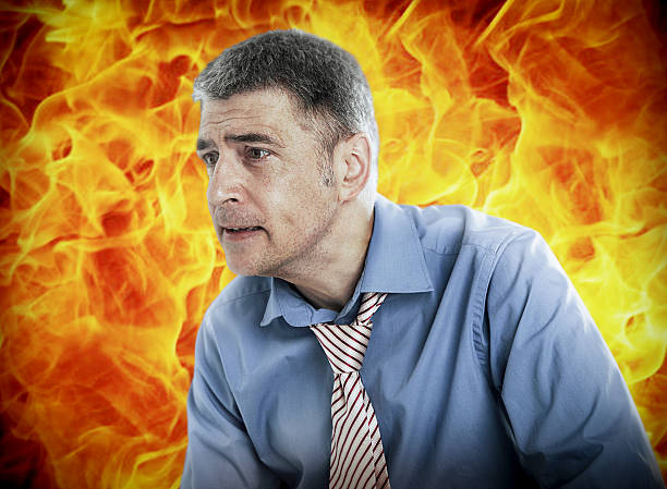 istock Worried businessman with fire in background 497281159