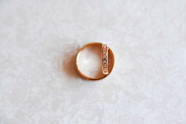 istock Golden wedding rings with diamonds on white pattern background. 497282742