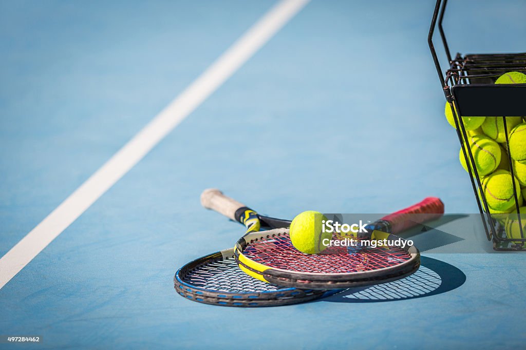 Tennis Practice tennis balls in a basket with a racket. Tennis Stock Photo