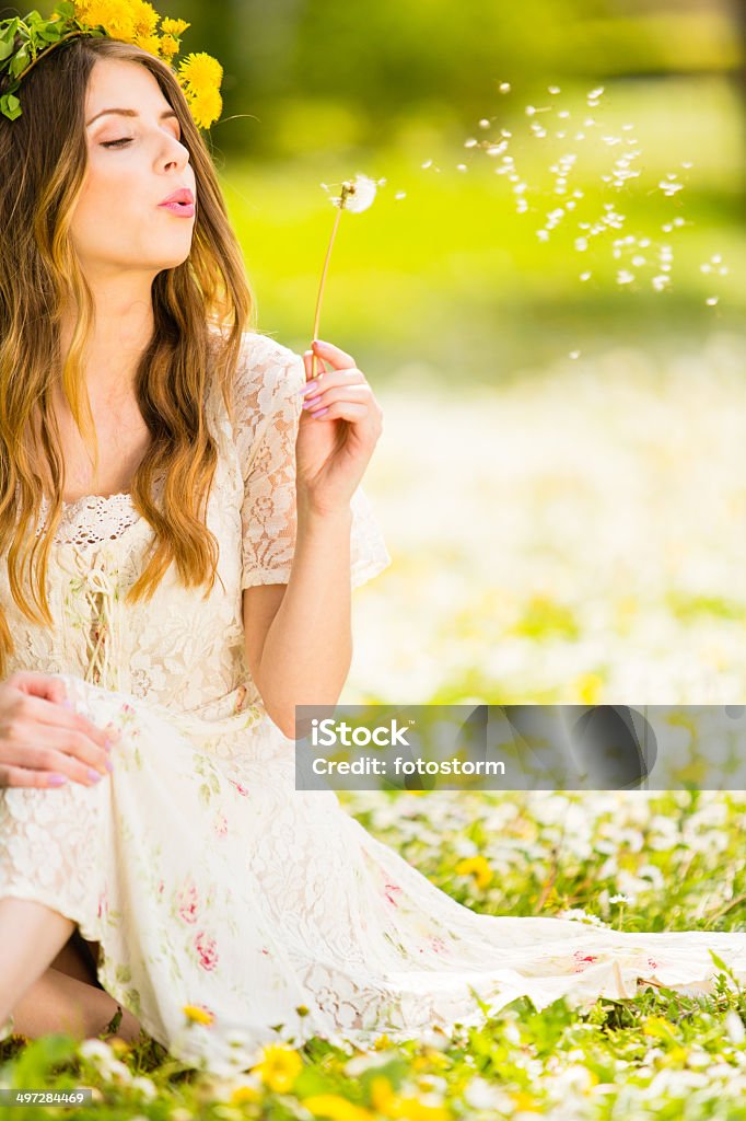 Woman blowing a dandelion Woman blowing a dandelion. Adult Stock Photo