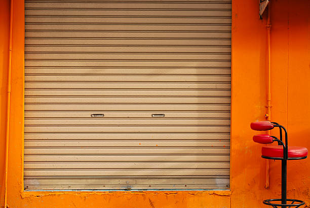 istock Shuttered roll up metal door with orange wall 497297709