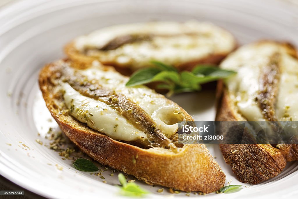 Crostini with fish, mozzarella and oregano Crostini with anchovy fish, mozzarella and oregano Anchovy Stock Photo